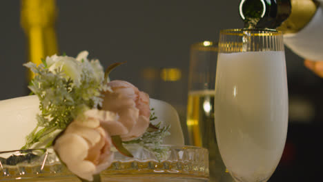 Nahaufnahme-Einer-Person,-Die-Bei-Der-Hochzeitsfeier-Champagner-In-Ein-Glas-Gießt,-Am-Gedeckten-Tisch-3